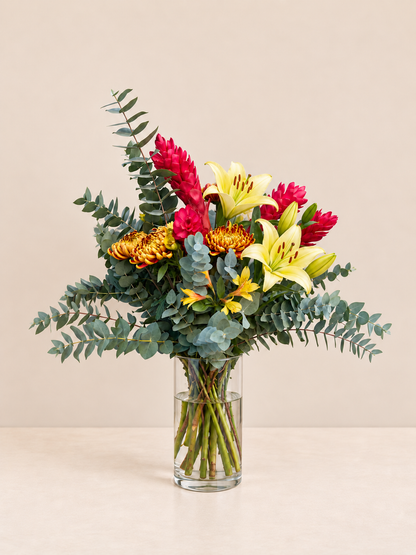 Arranjo do Dia com lírios amarelos e flores vermelhas em vaso de vidro, tamanho M